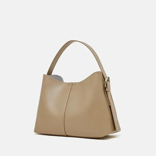 Beige leather hobo bag with single handle and side buckle on white background