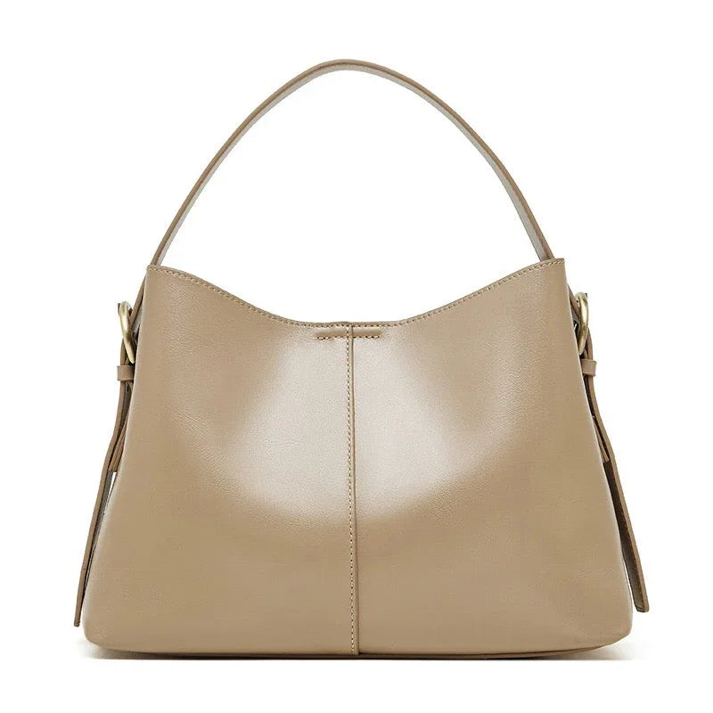 Beige leather hobo handbag with a single strap and gold-tone hardware on white background