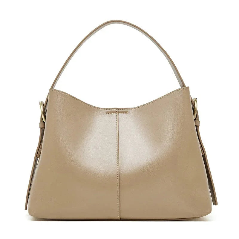 Beige leather hobo handbag with a single strap and gold-tone hardware on white background