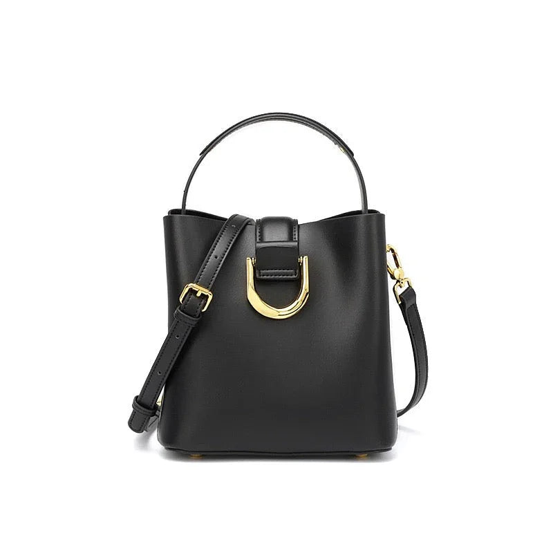 Black leather bucket bag with gold hardware and adjustable shoulder strap on white background