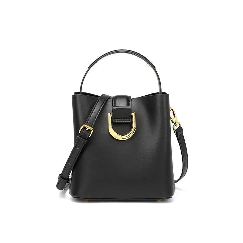 Black leather bucket bag with gold hardware and adjustable shoulder strap on white background