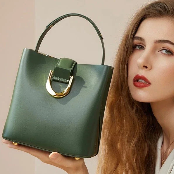 Woman posing with a green leather handbag featuring a gold buckle, fashion accessory