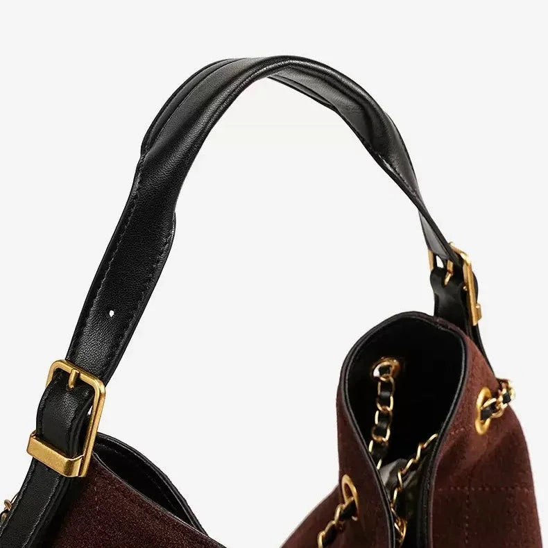 Brown suede handbag with black leather strap and gold hardware detail