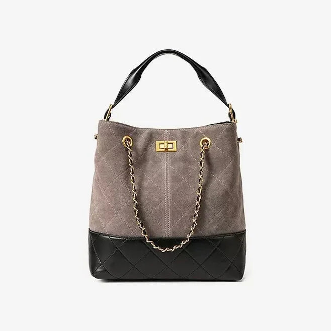 Two-tone quilted bucket bag with gold chain strap and black leather handle