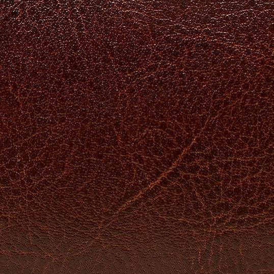 Close-up of brown genuine leather texture with natural grain and creases