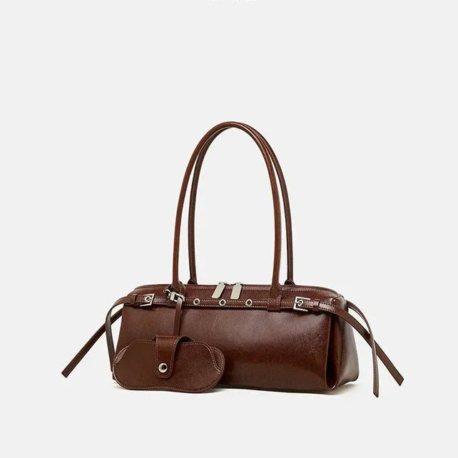 Brown leather handbag with long handles and matching pouch on white background