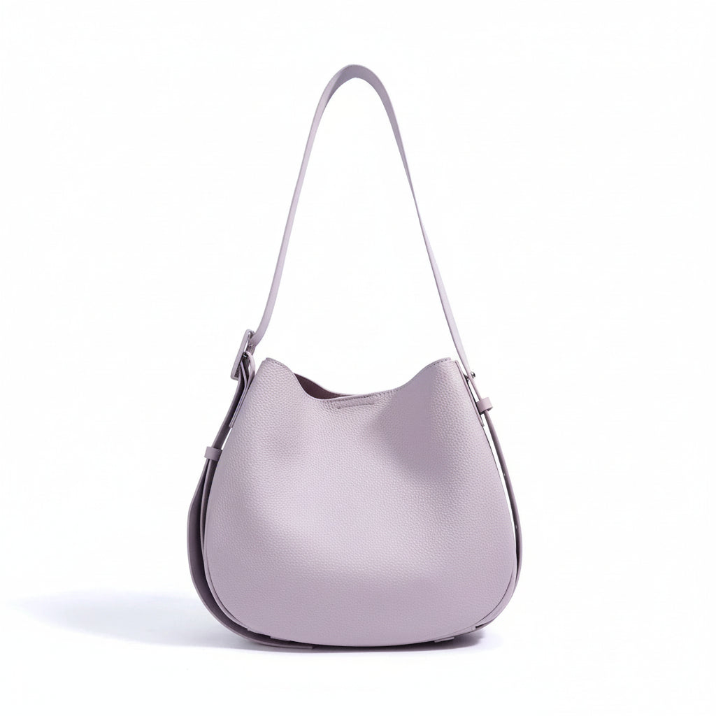 Light purple leather shoulder bag with adjustable strap on white background