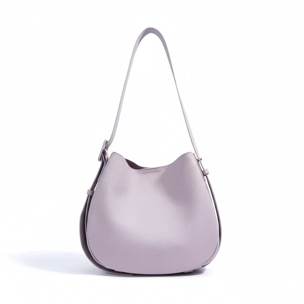 Light purple leather shoulder bag with adjustable strap on white background