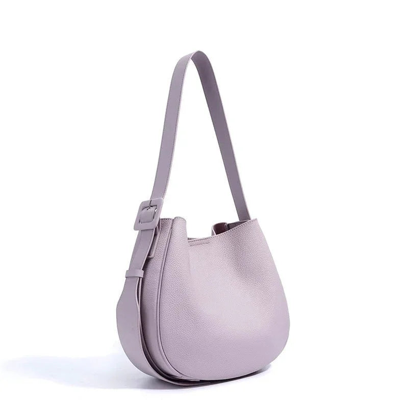Lilac leather shoulder bag with adjustable strap and minimalist design on white background