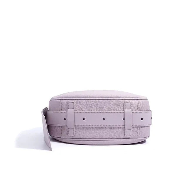 Lavender leather crossbody bag with textured finish and adjustable strap on white background