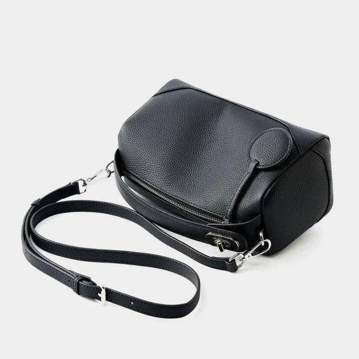 Black leather crossbody bag with textured finish and adjustable strap on white background