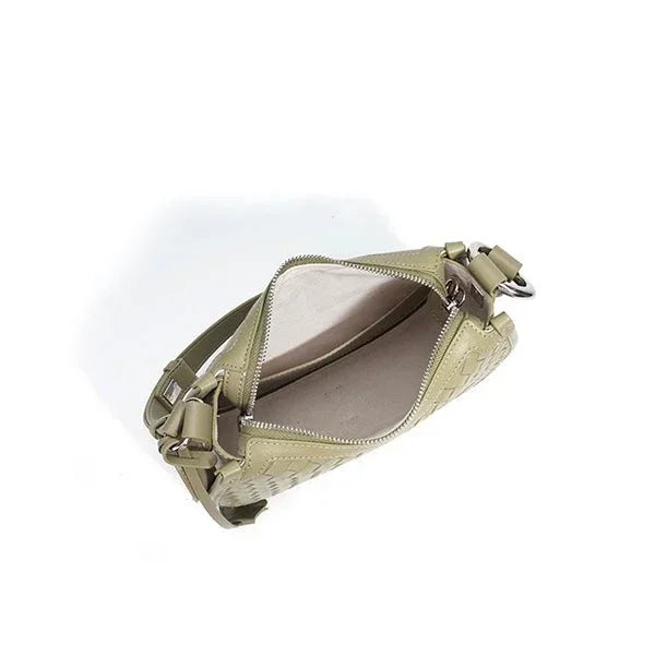 Open light green woven leather crossbody bag with zipper and adjustable strap on white background