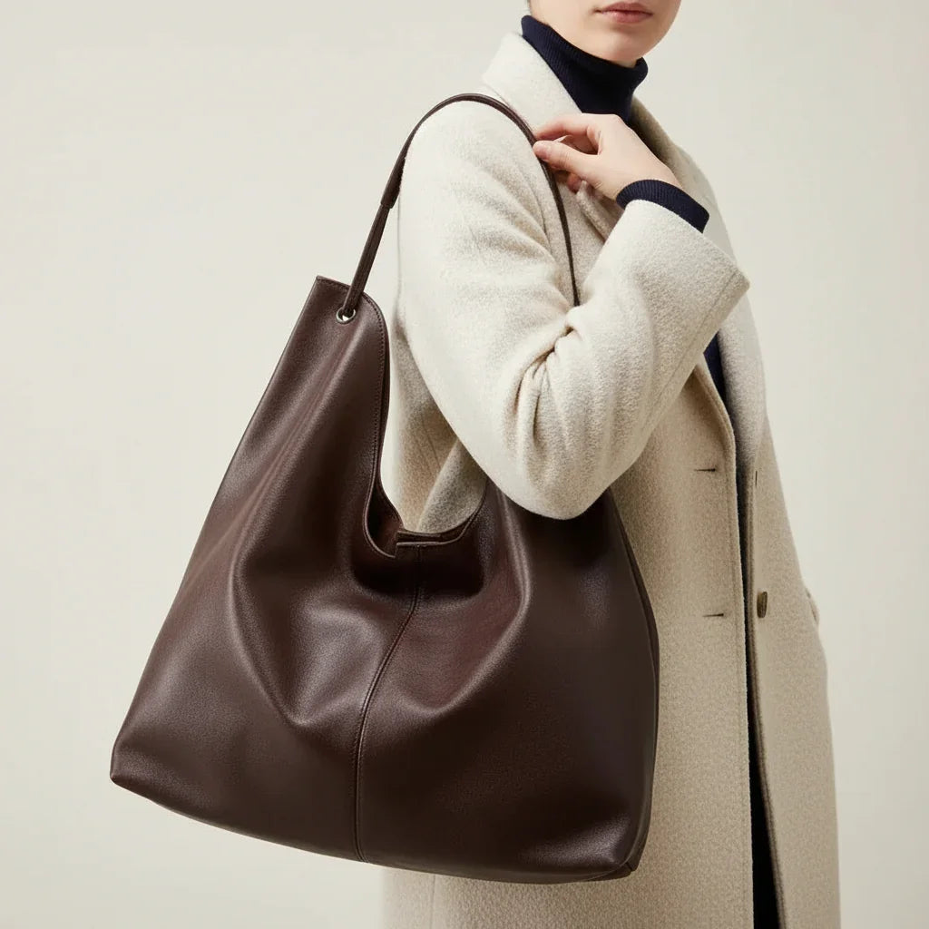 Woman wearing brown oversized leather tote bag with brown trench coat