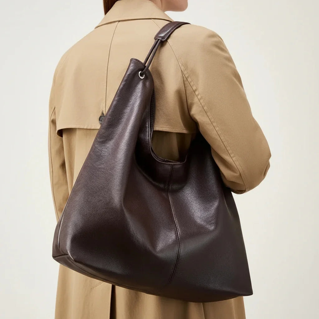 Large brown leather shoulder bag on person in tan blazer