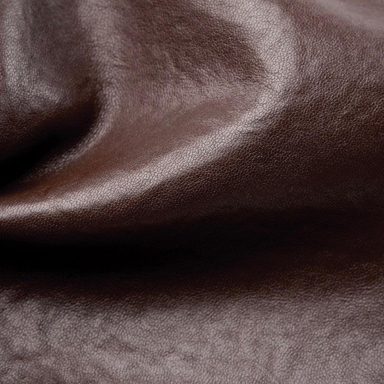 Close-up of smooth brown leather texture with subtle natural grain detail