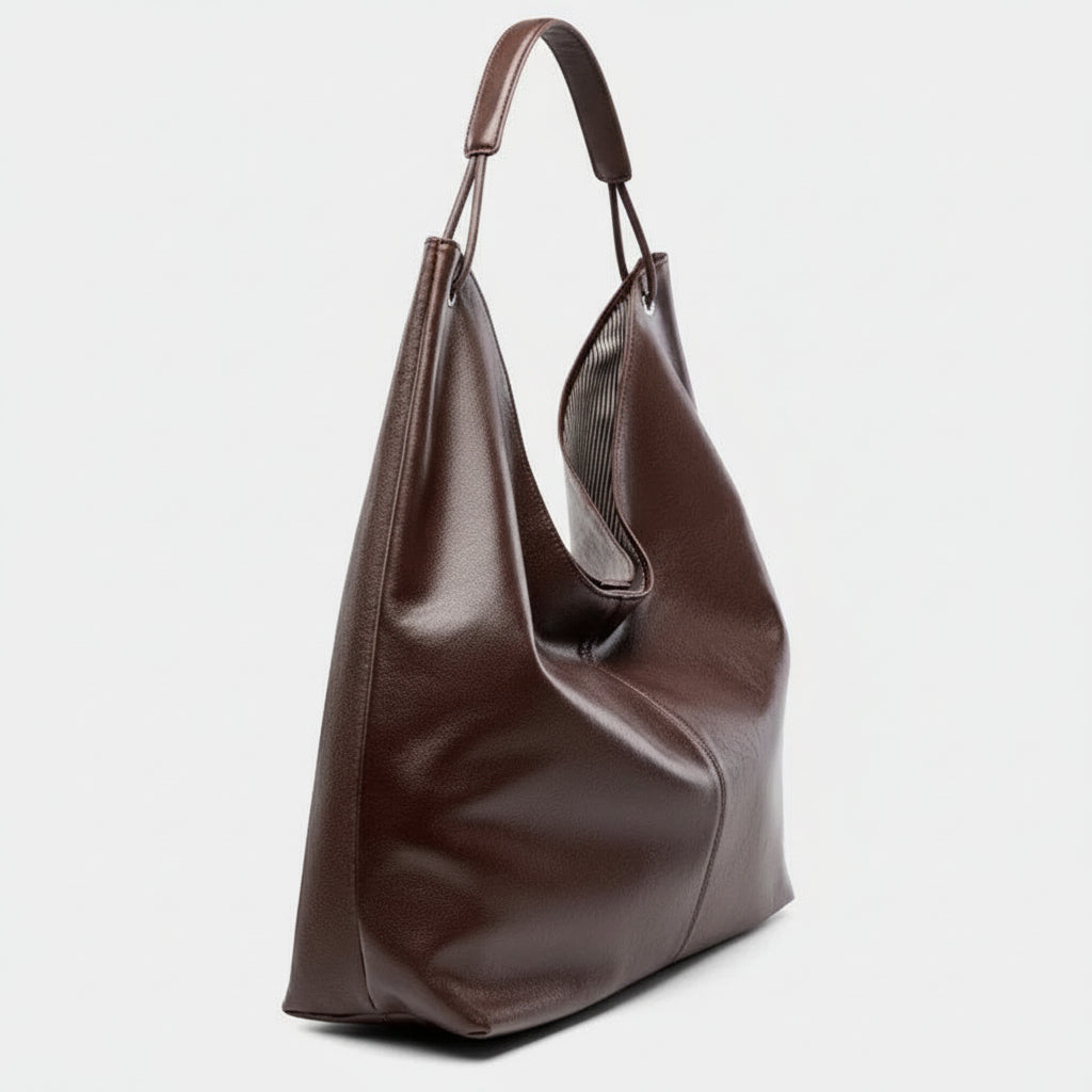 Brown leather hobo bag with single handle on a plain light background