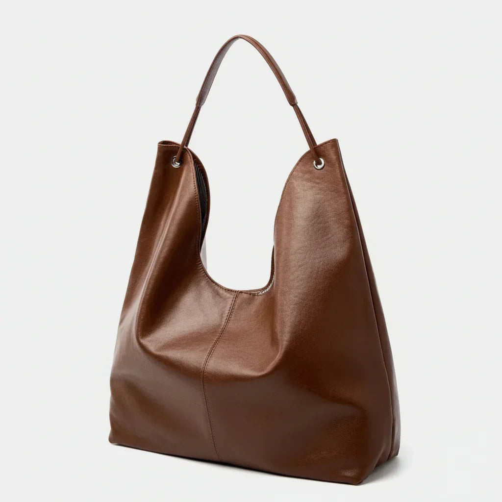 Brown leather tote bag with single handle on white background