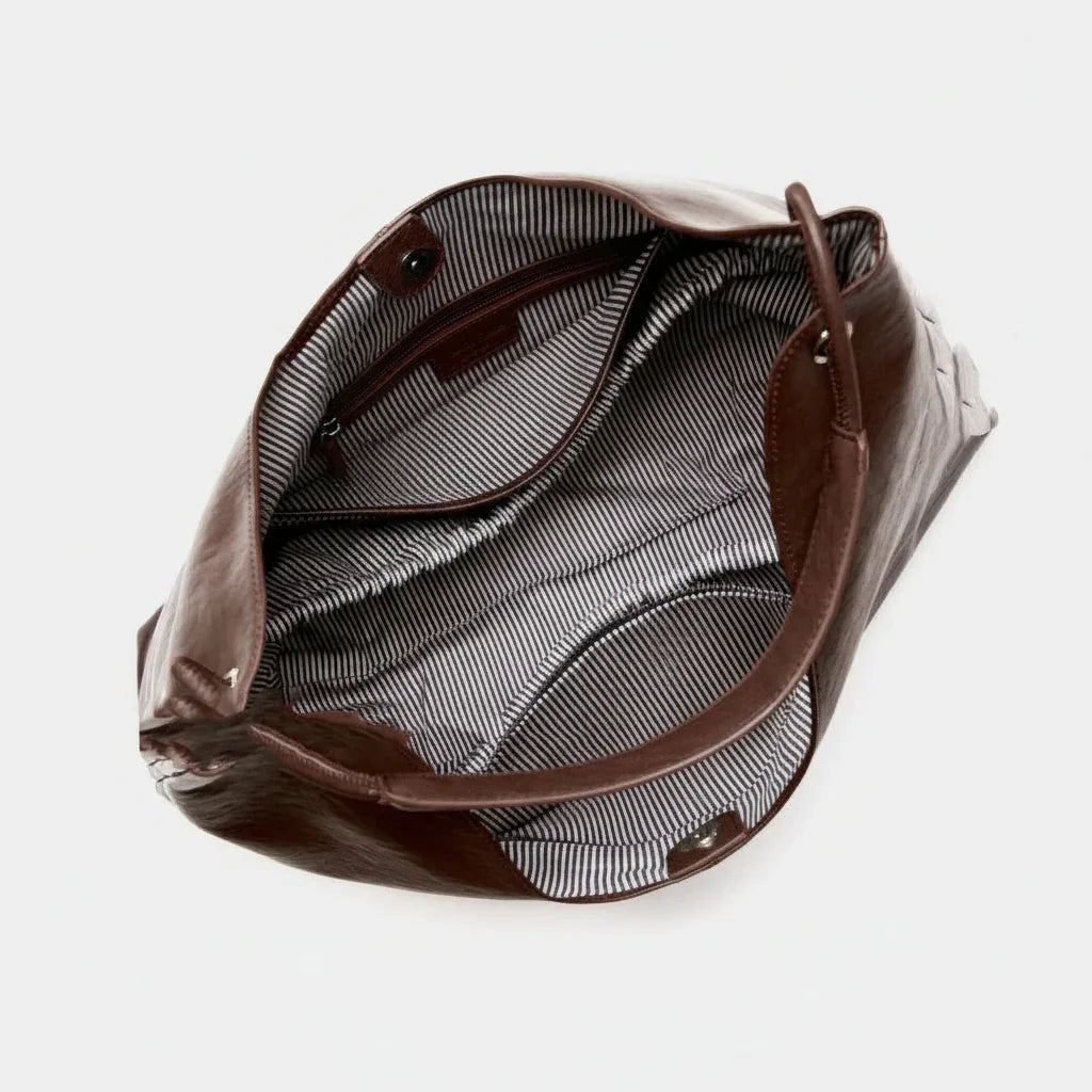 Open brown leather tote bag with striped interior and snap closures