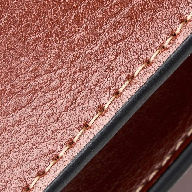 Close-up of brown leather wallet with detailed stitching and textured surface