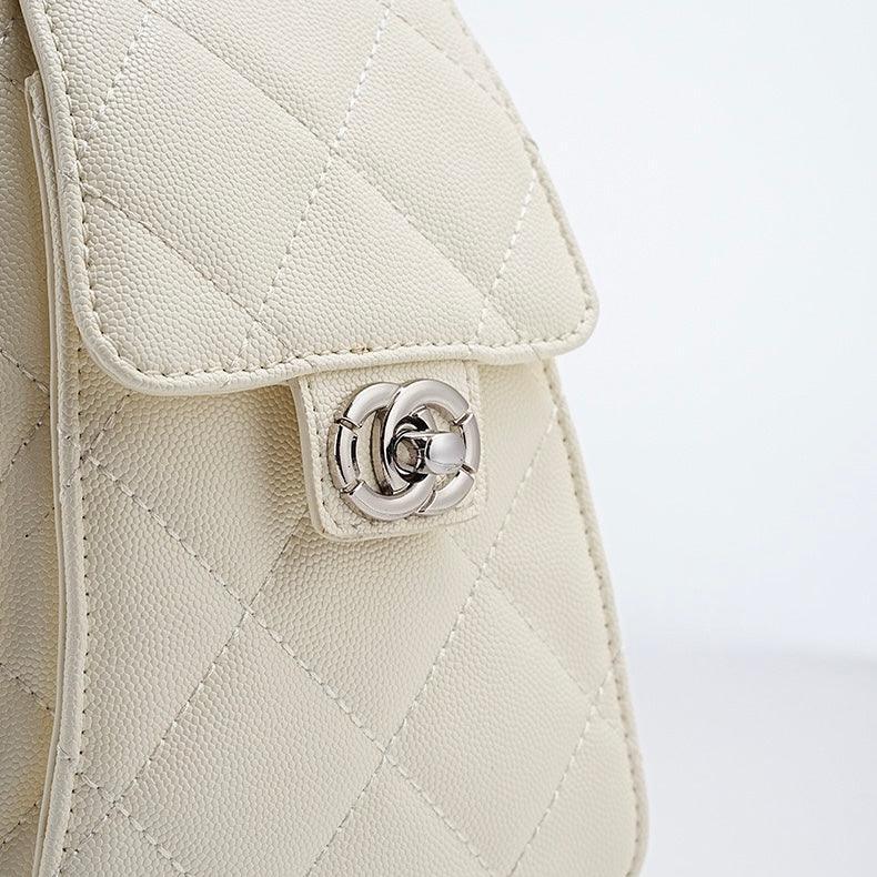Close-up of quilted cream leather handbag with silver twist-lock clasp