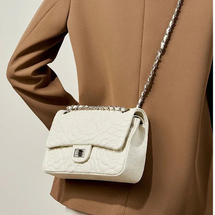 White quilted leather shoulder bag with chain strap on person in tan blazer