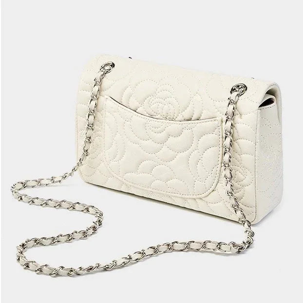 White quilted leather shoulder bag with floral stitching and silver chain strap