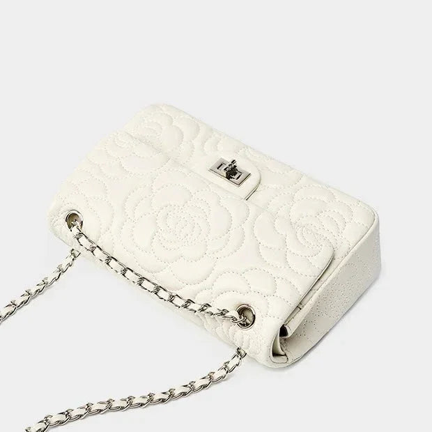 White quilted leather shoulder bag with floral pattern and silver chain strap