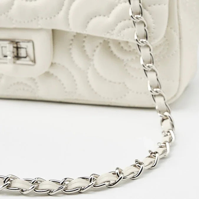 Quilted white leather handbag with silver chain strap and floral stitching detail