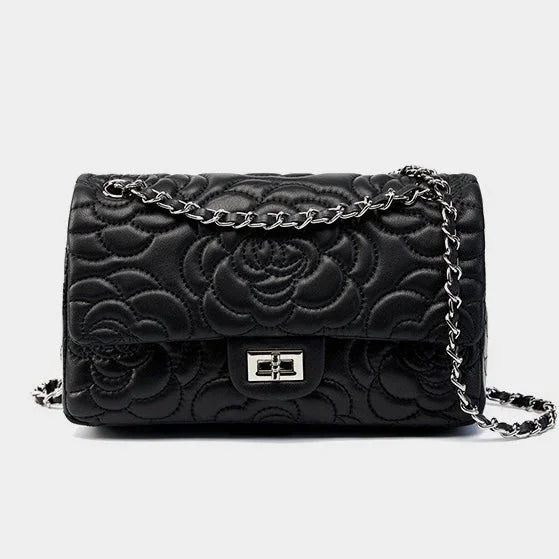 Black quilted leather handbag with floral pattern and silver chain strap