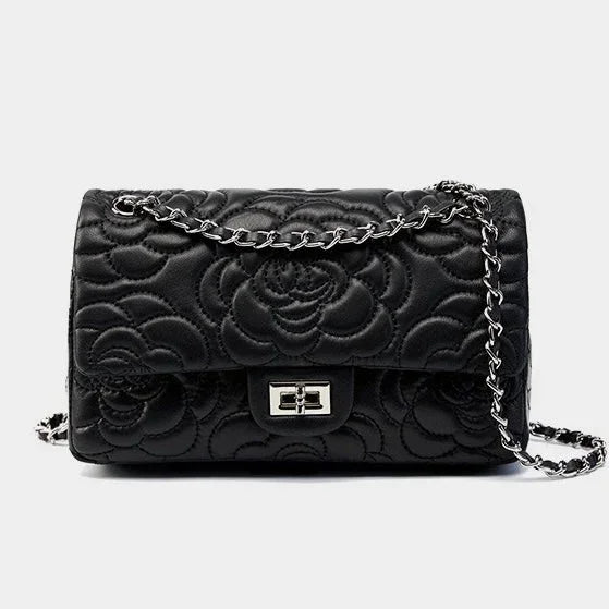 Black quilted leather handbag with floral pattern and silver chain strap