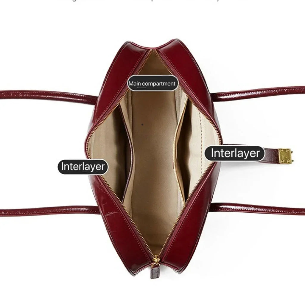 Top view of a burgundy leather handbag showing labeled main compartment and two interlayers