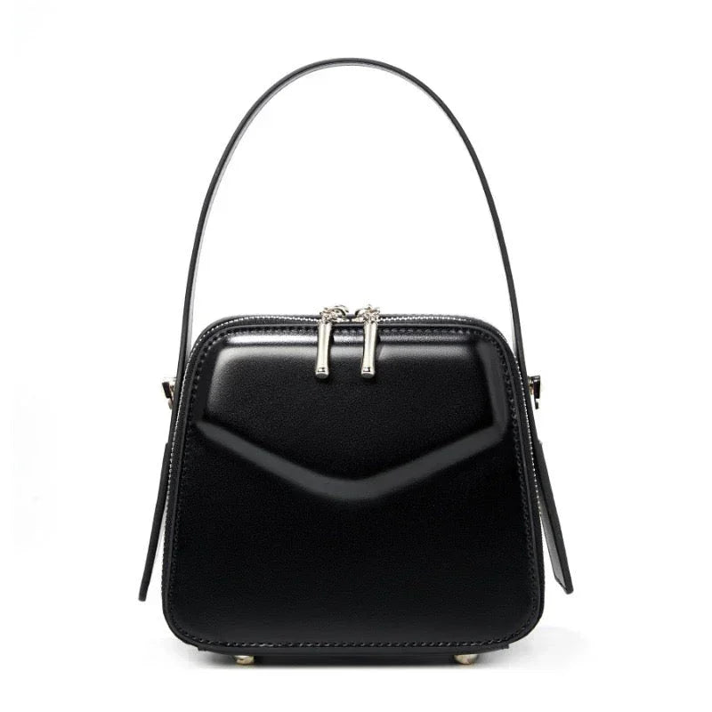 Black square leather handbag with top handle and silver zipper accents on white background