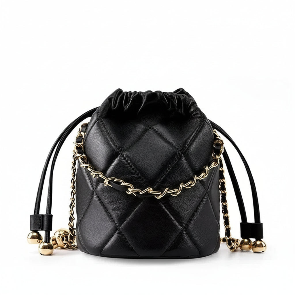 Black quilted leather drawstring bucket bag with gold chain and metallic accents on white background