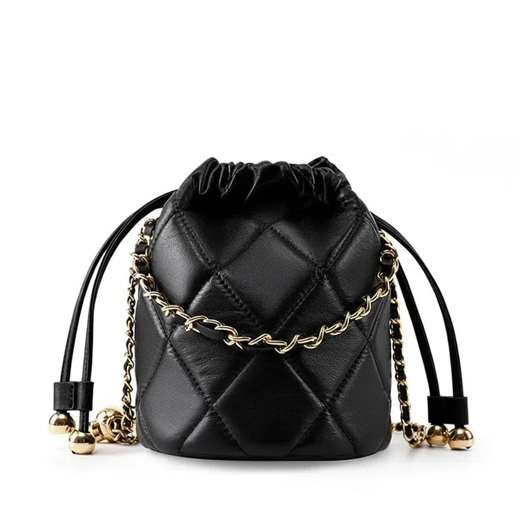 Black quilted leather drawstring bucket bag with gold chain and metallic accents on white background