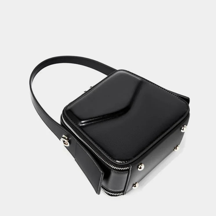 Black square leather crossbody bag with silver studs and zipper on white background