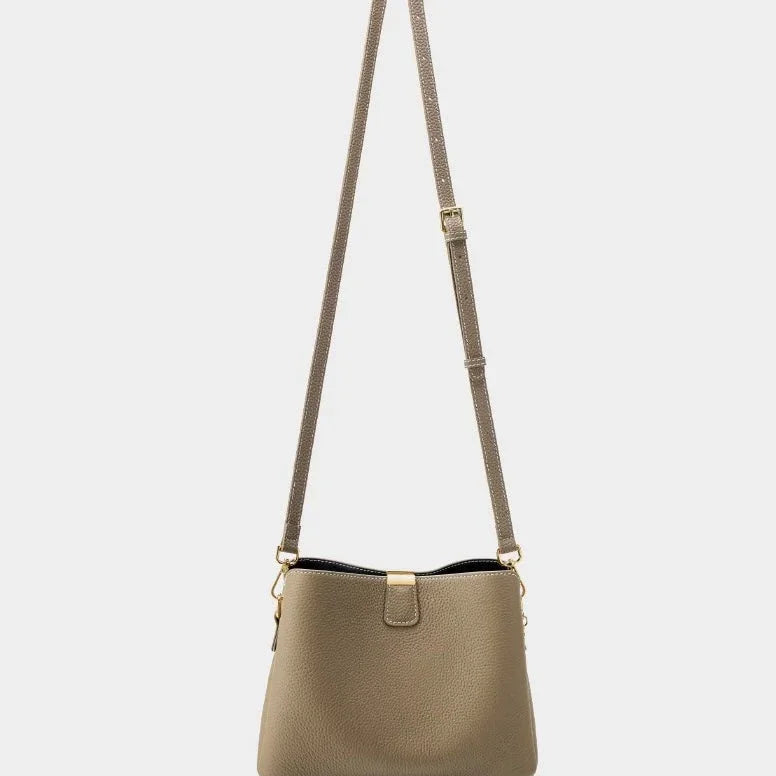 Taupe leather crossbody bag with adjustable strap and gold hardware on white background
