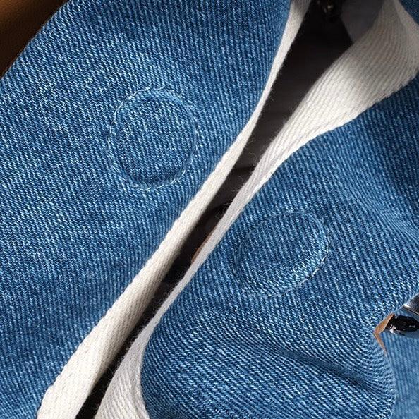 Close-up of blue denim sneakers with white soles and stitched circular accents