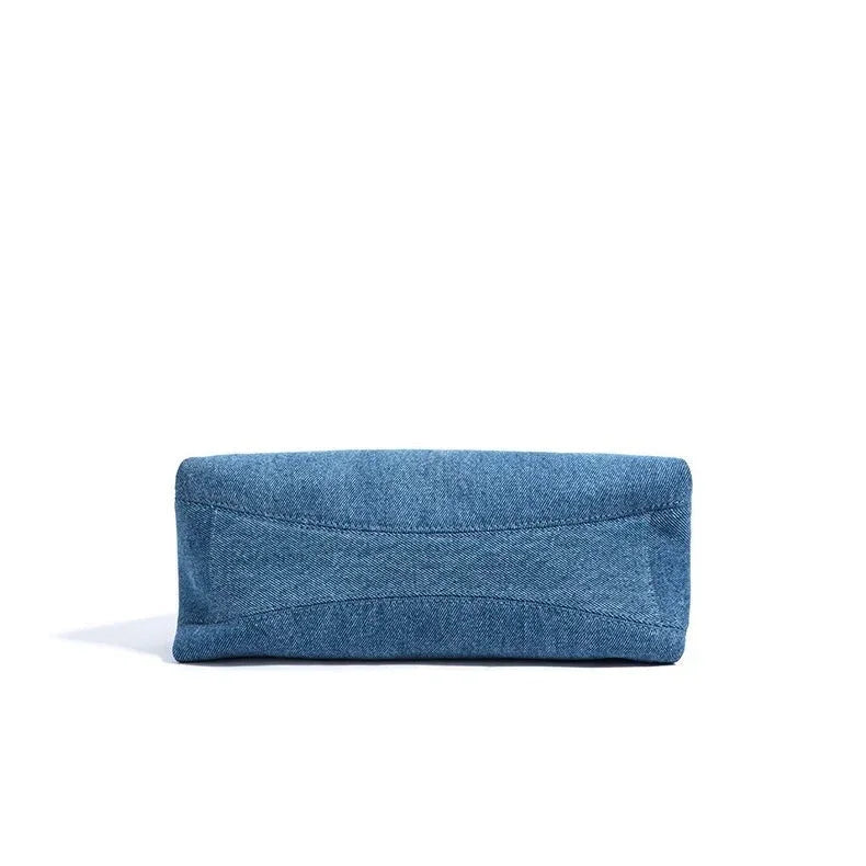 Blue denim pouch bag on white background, minimalist accessory photo