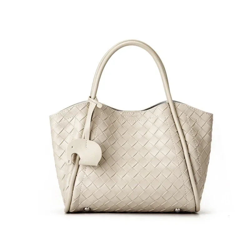 Beige woven leather tote bag with double handles and elephant-shaped leather charm