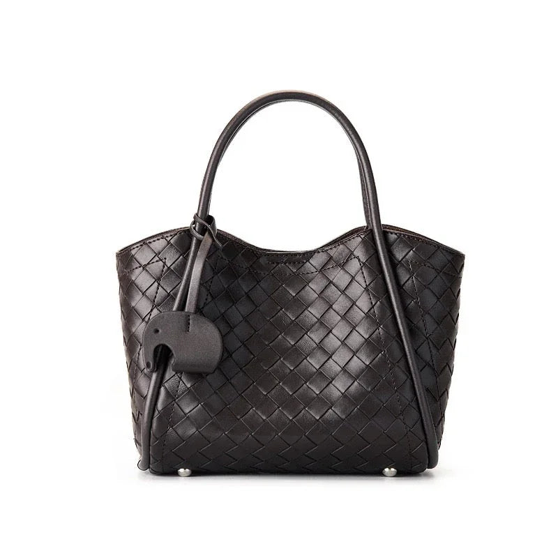 Black woven leather tote bag with double handles and an elephant-shaped charm
