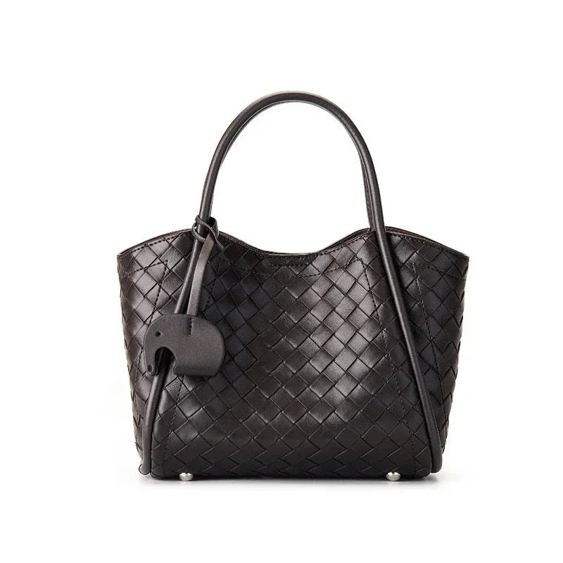 Black woven leather tote bag with double handles and an elephant-shaped charm