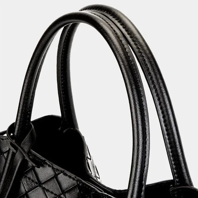 Black quilted leather handbag handle detail on white background