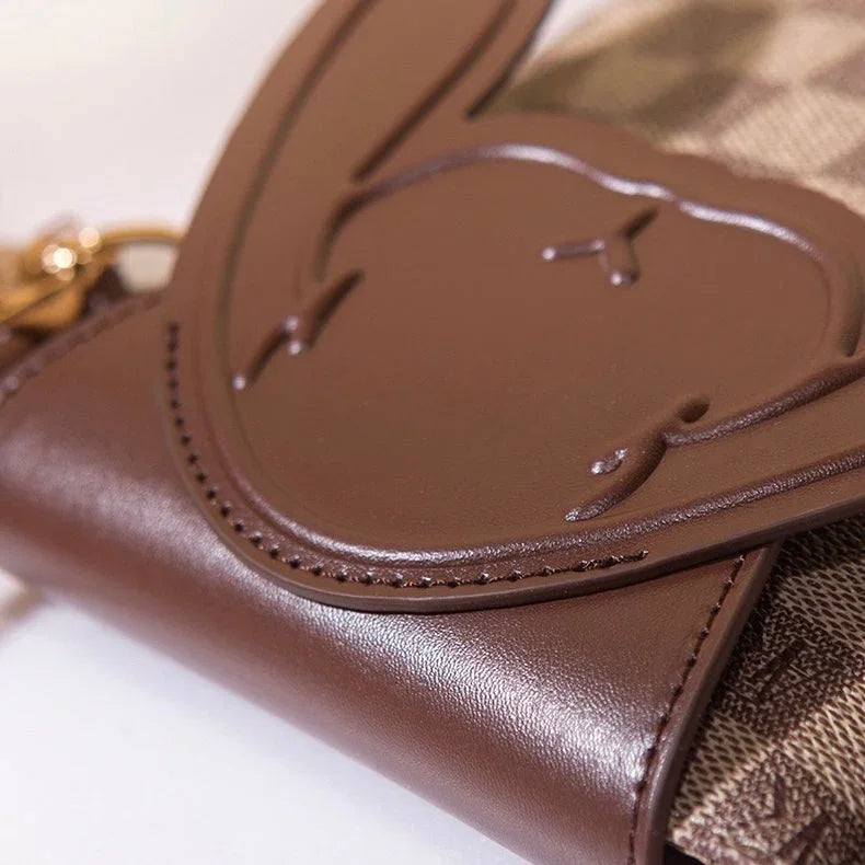 Closeup of brown leather wallet with embossed bunny face and checkered fabric accent