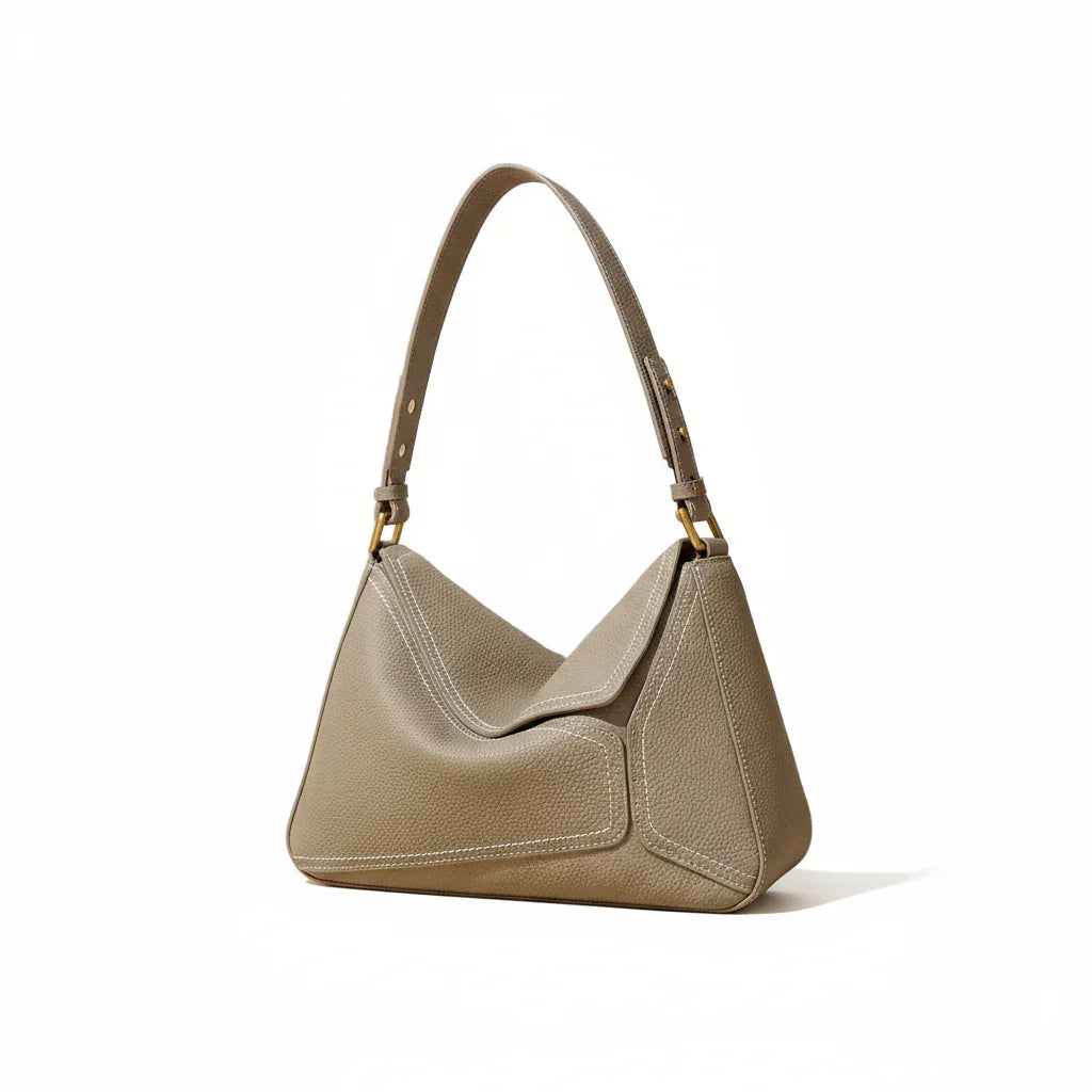 Taupe leather shoulder bag with gold hardware on a neutral background
