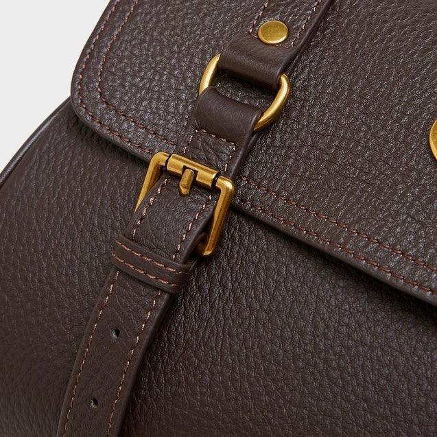 Close-up of a brown leather bag with gold buckle and textured stitching detail