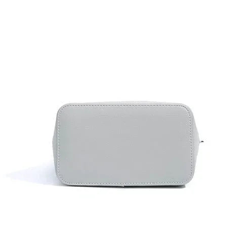 Light gray leather handbag bottom view on white background, minimalist style purse