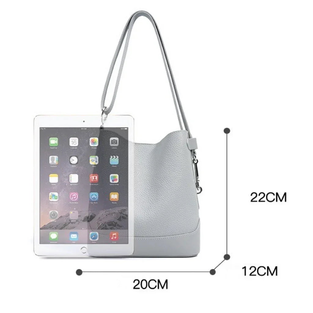 Light gray leather shoulder bag with size measurements and an iPad for scale