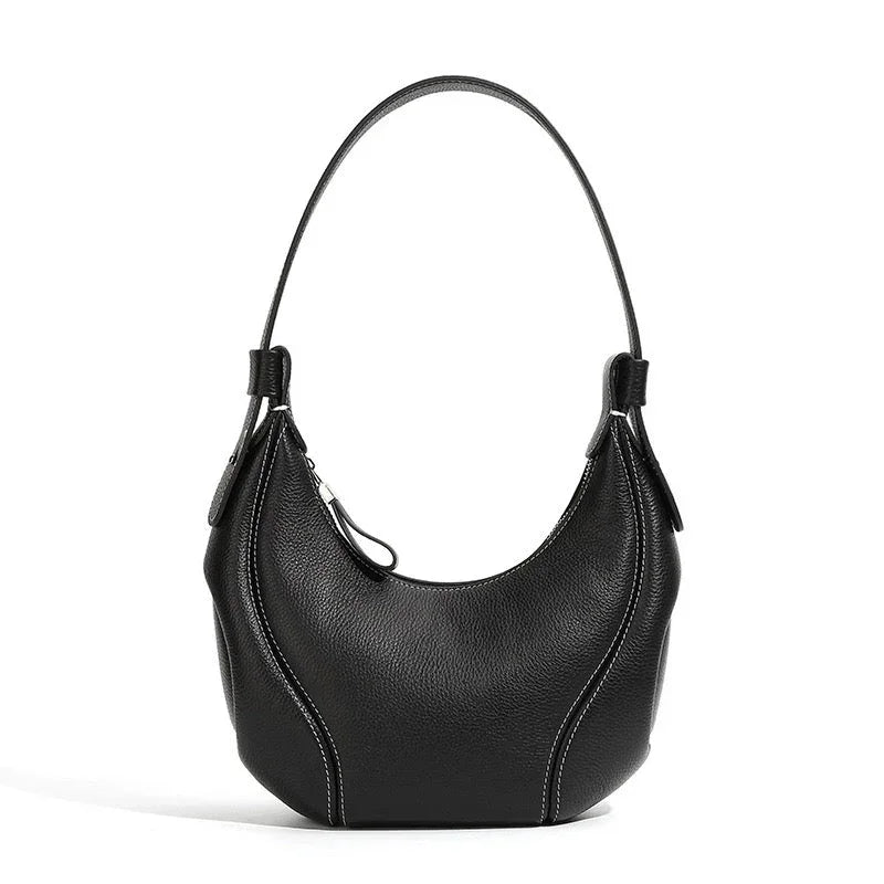 Black leather shoulder bag with curved design and white stitching on white background