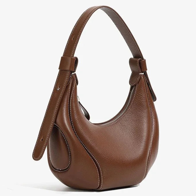 Brown leather crescent shoulder bag with white stitching on a white background