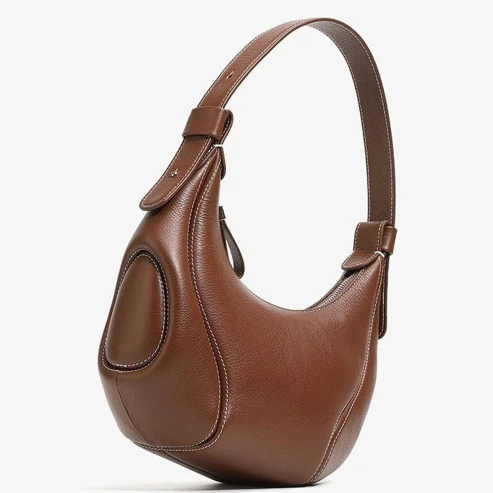 Brown leather shoulder bag with curved ergonomic design and visible stitching